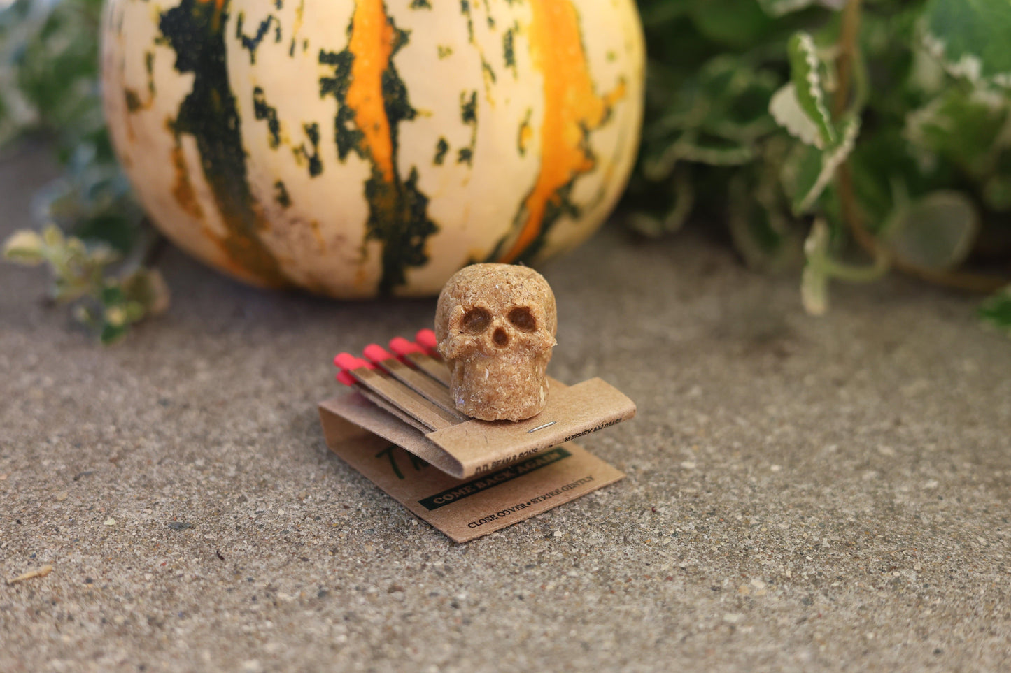 Mini human skull fire starter in use, lighting a bonfire with ease, showcasing long burn time and eco-friendly design