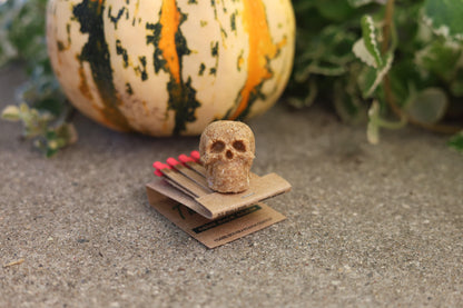 Mini human skull fire starter in use, lighting a bonfire with ease, showcasing long burn time and eco-friendly design