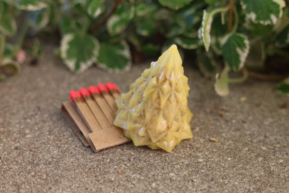 Natural beeswax geometric Christmas tree fire starter made with recycled sawdust, pine shavings, and beeswax for a sustainable fire-lighting solution